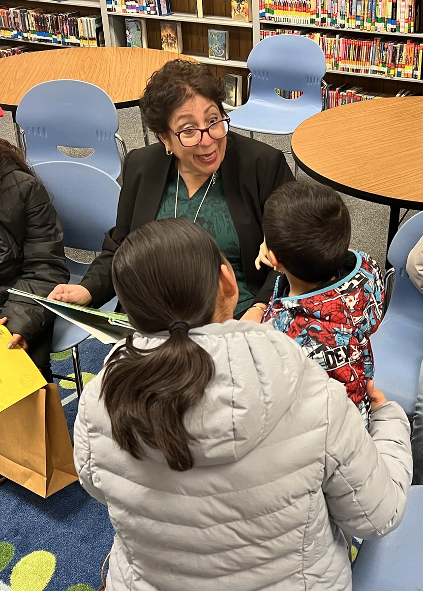 Walta Gamoian speaking with students and a family in a school library